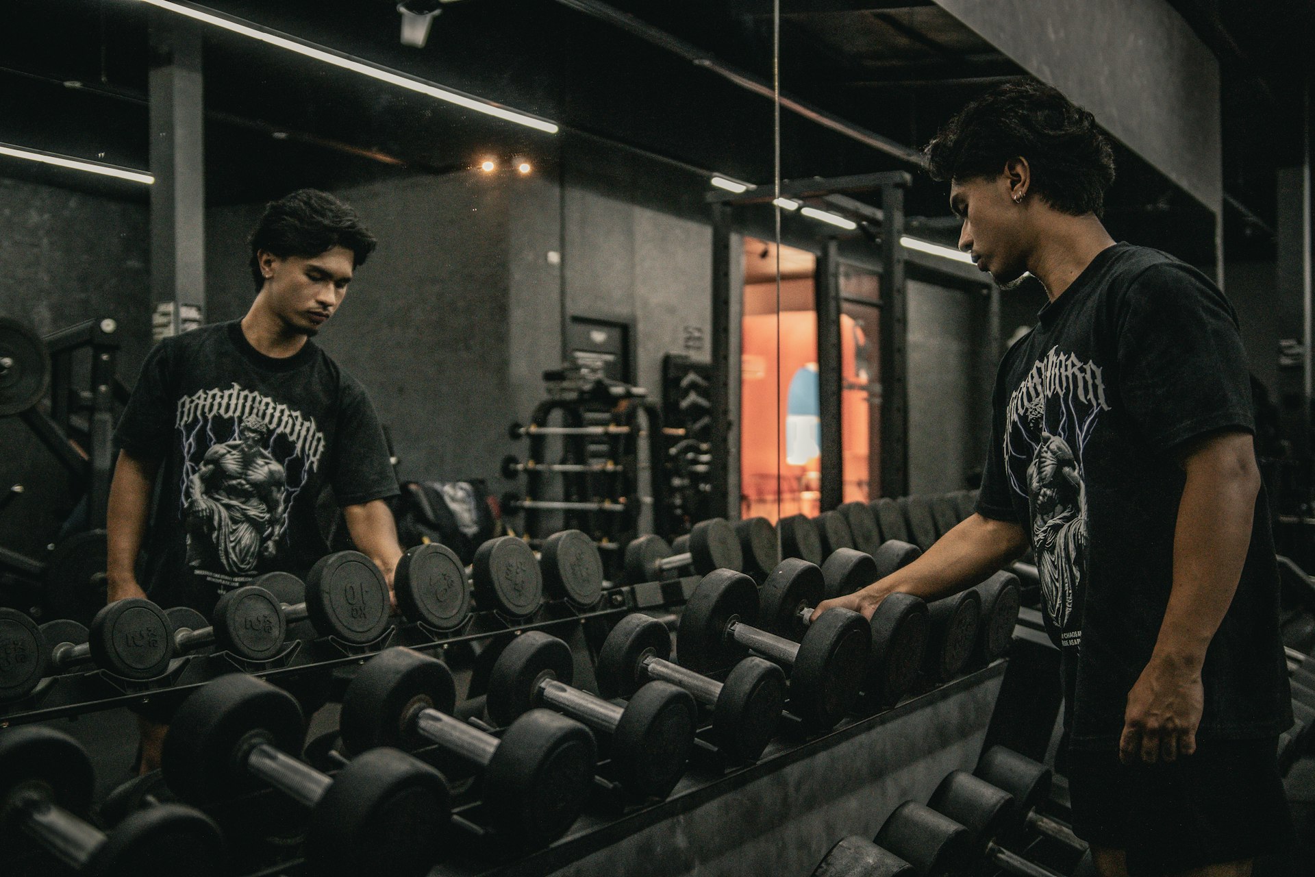 A couple of men standing next to each other in a gym